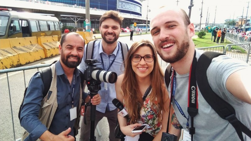 Foto com quatro repórteres fotográficos em frente a Arena do Grêmio